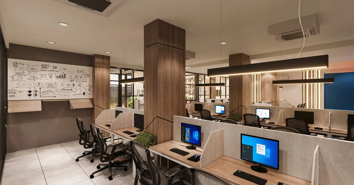 Espace de bureau contemporain avec cubicles, ordinateurs, et un mur de tableau créatif dans un environnement professionnel.