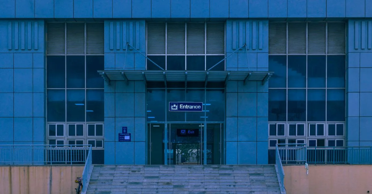 Entrée d'un bâtiment moderne à façade bleue à Lagos, Nigeria, avec un design symétrique.