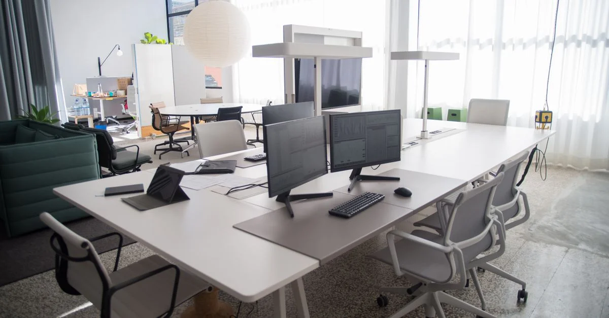 Espace de travail de bureau ouvert, spacieux et organisé, avec des meubles modernes et un éclairage naturel.