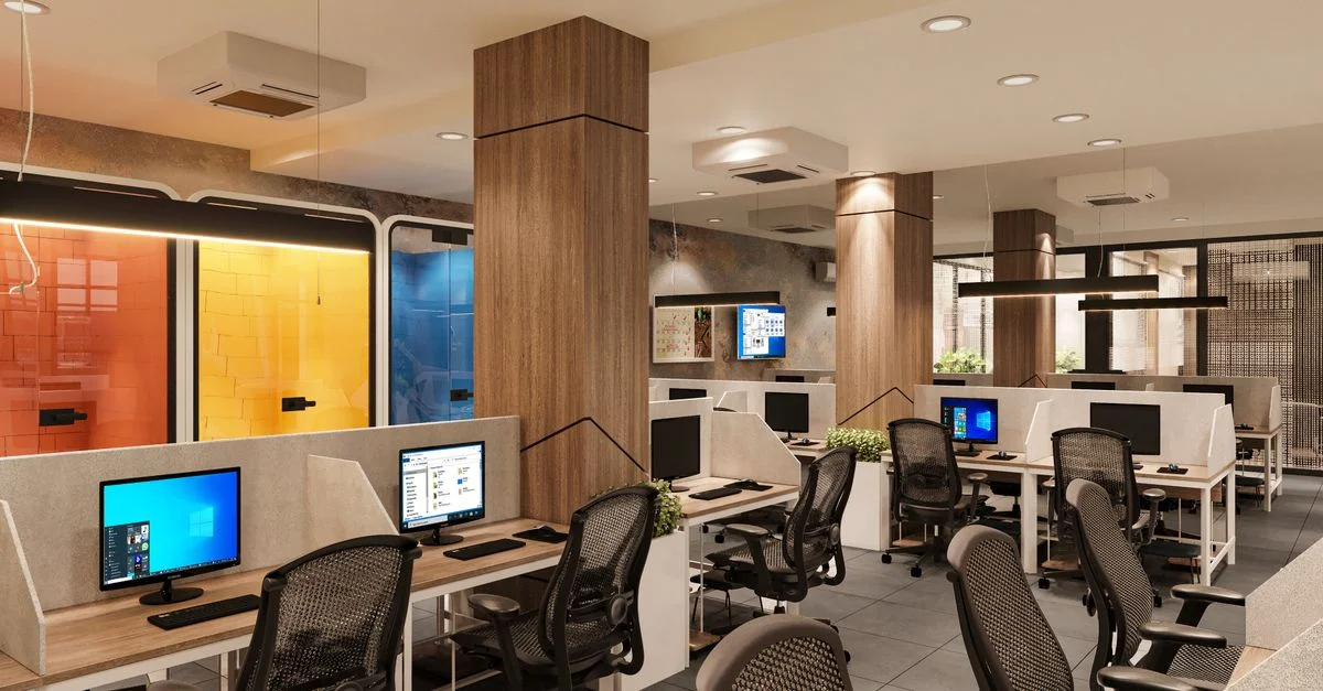 Intérieur de bureau moderne, lumineux et spacieux, avec des postes de travail et des éléments colorés.